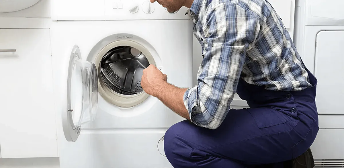 Handyman inspecting a dryer drum and internal parts for repair in Chattanooga, TN